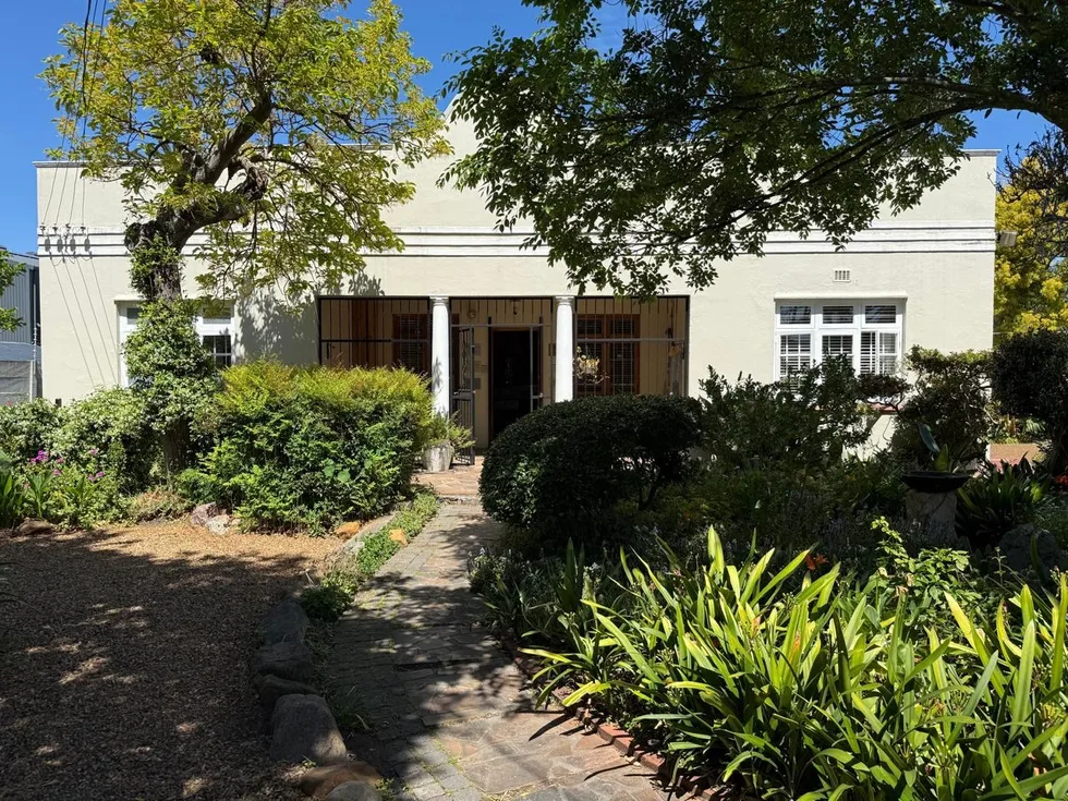 The front of Renée’s practice building in Wynberg, seen through the garden, with a stone path to the door
