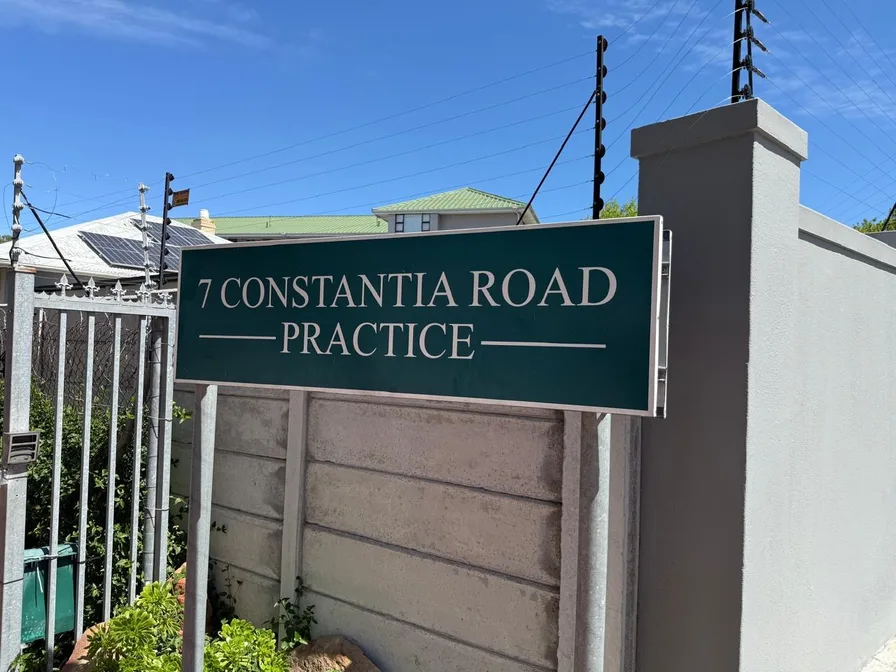 The green practice sign on the wall beside the gate