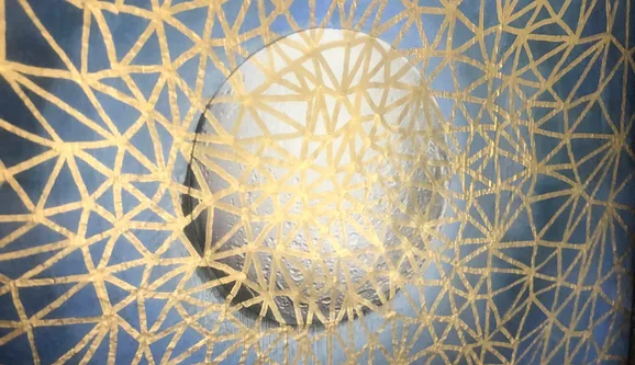 A golden geometric lattice over deep blue, around a pale glowing circle
